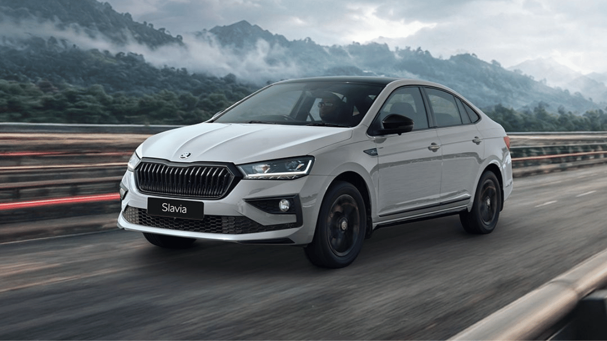 The limited-edition sedan that actually rewards early buyers 1 Steel grey Skoda Slavia sedan with black roof and black wheels driving on road with foggy mountains behind.