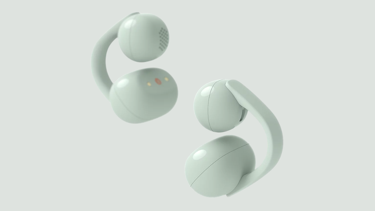 Why urban professionals are switching to open acoustics? 1 Two light green open-ear headphones showing inner acoustic mesh speaker holes and smooth outer clipping hooks.
