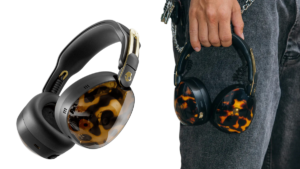 Skullcandy Aviator 900 ANC headphones with tortoise shell earcups, held against grey denim jeans in lifestyle view.