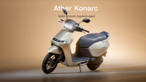 Front disc wheel, apron light bar, handlebar headlamp, and flat seat on the Ather Konarc scooter studio backdrop.