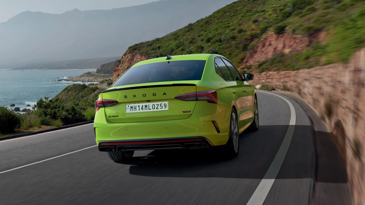 High-performance Octavia RS arrives with track hardware 4 Green car driving away showing black rear boot spoiler, led tail lamps, and lower exhaust diffuser on road car.