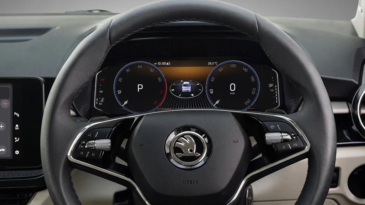 Updated midsize sedan debuts with revised styling 1 Two-spoke black steering wheel framing a digital instrument cluster showing twin circular dials cockpit.