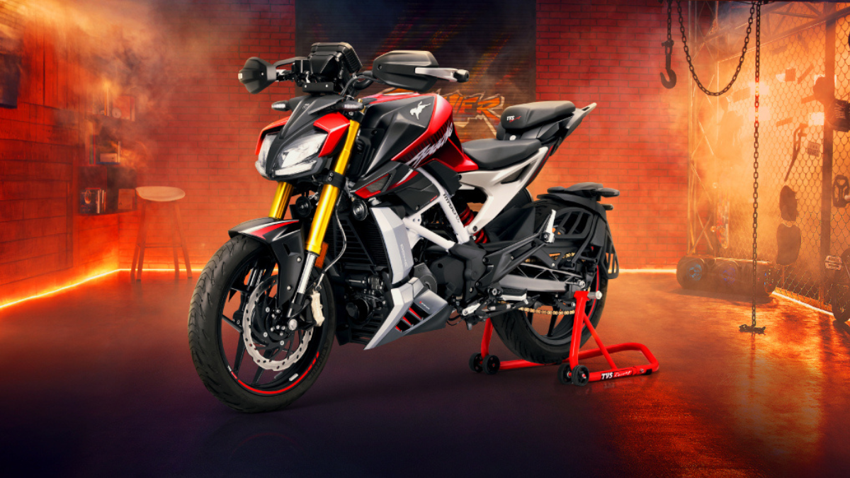Keyless ignition reaches Apache RR 310 at Rs 2.88 lakh 1 Black front wheel, gold forks, twin headlamps, red fuel tank, red paddock stand, lit brick wall motorcycle.