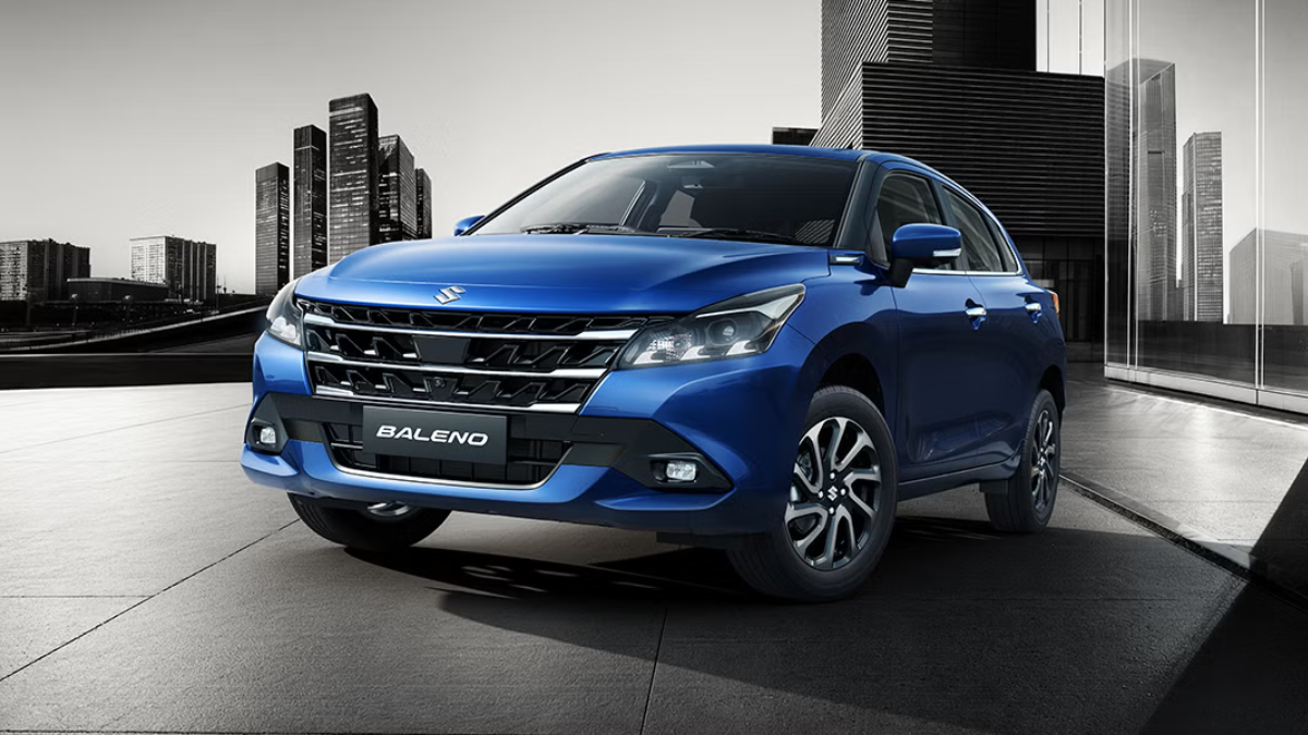 Updated 2026 Baleno arrives in India with segment-first ADAS 1 A blue car angled on a paved foreground, with multi-spoke wheels on the side and city high-rises in the background.