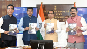 Four men standing behind a table holding DILRMP 3.0 booklets in front of Indian flags launch.