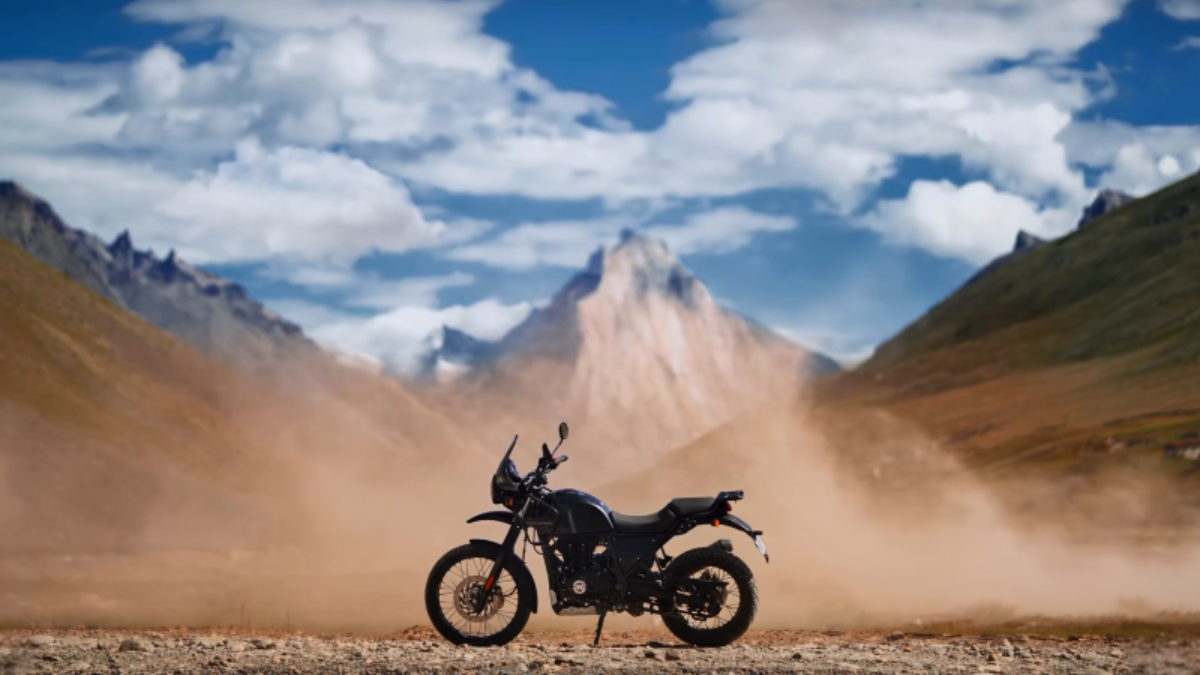 New Himalayan 440 goes on sale in India at ₹2.29 lakh 1 A parked dark motorcycle stands in profile amid dust on dirt ground, backed by a prominent mountain peak under clouds.