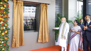 Floral garland, plaque between gold curtains, Amit Shah and guests clapping, Max Smart Super Speciality Hospital unveiling.
