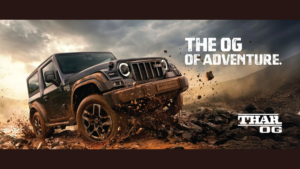 A Thar OG drives through mud on the left, with text banners on the right before an overcast rocky hill.