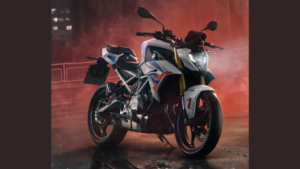 In the foreground, a BMW F 450 R sits angled right on wet ground, with red haze and dim city lights in the background.